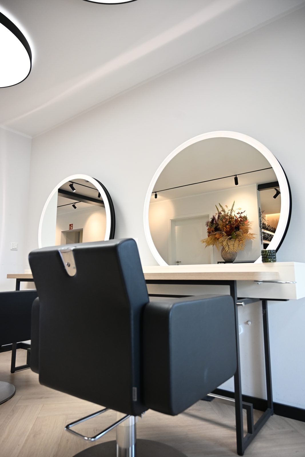 Bedienplätze mit runden Spiegeln im Salon Melanie B